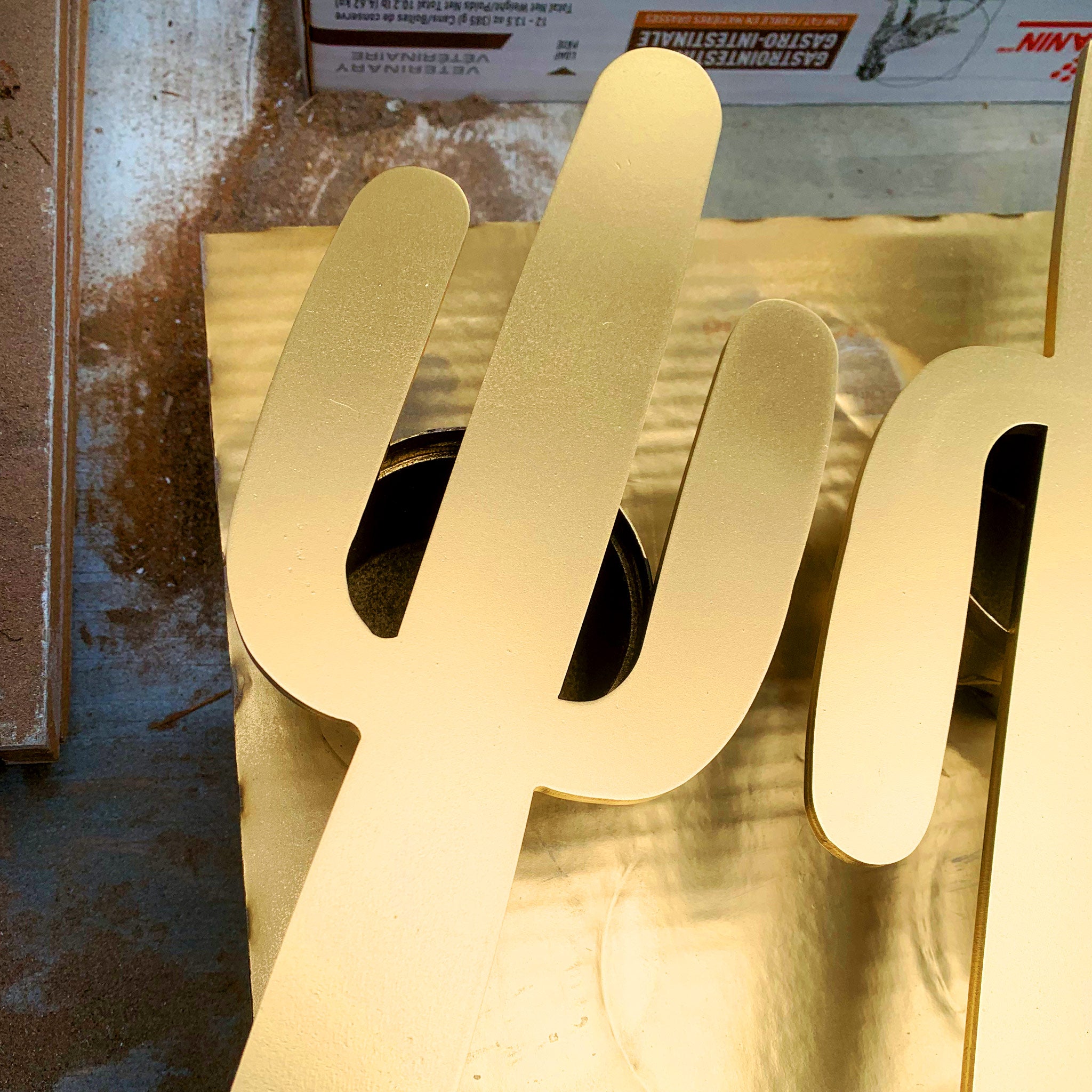Painted wood cactus drying in a workshop.