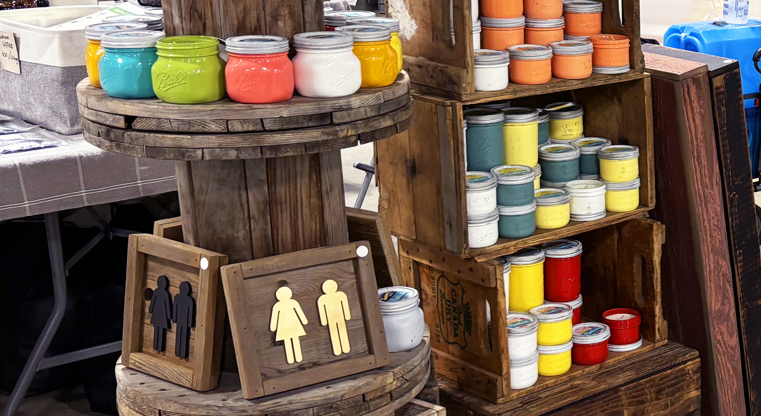 Colourful jars and wooden signs on a wooden stand.