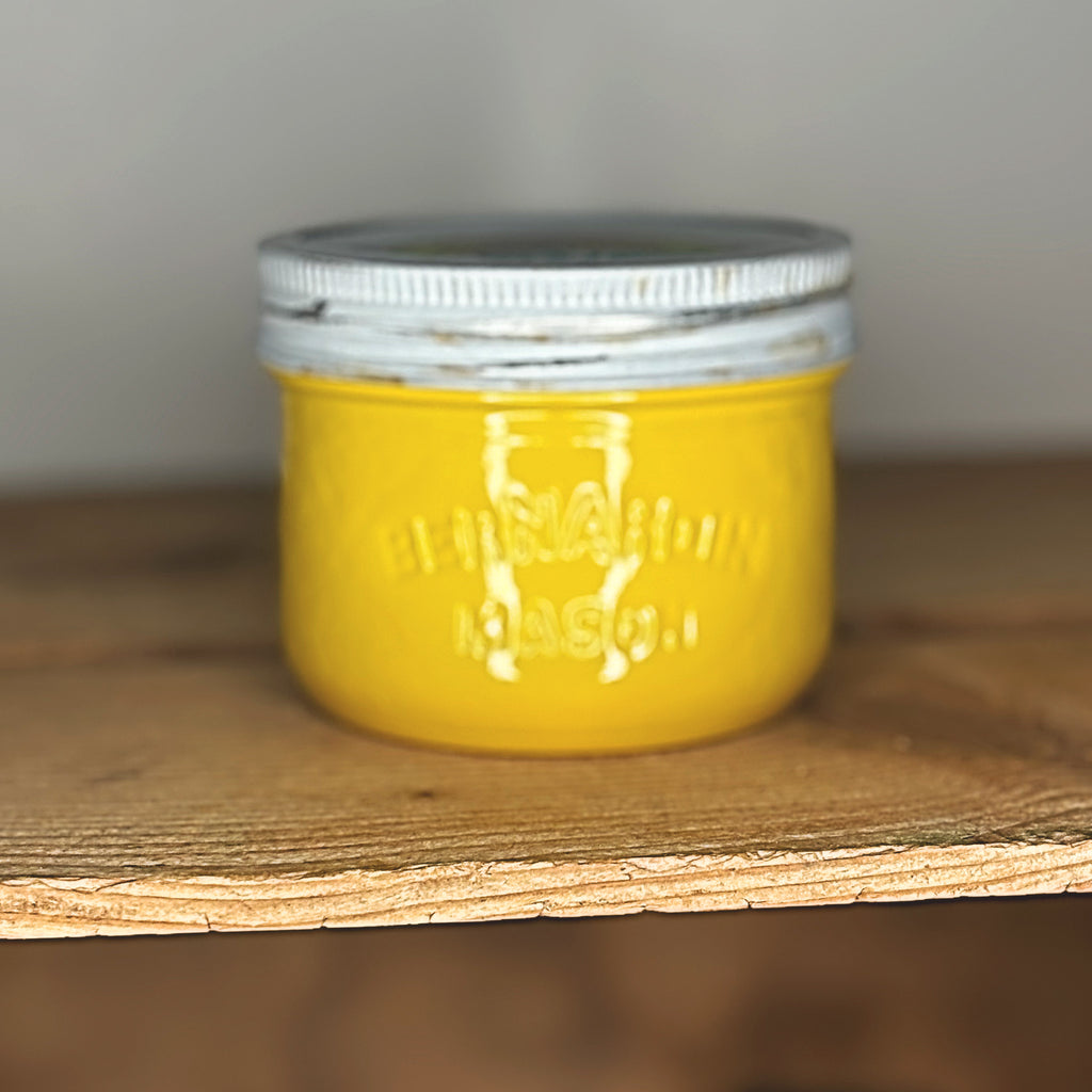 Yellow Jacket mason jar with a silver lid on a wooden surface.
