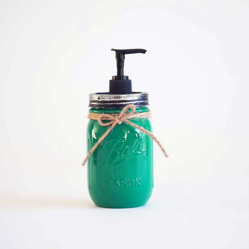 A green mason jar soap dispenser with a pump on a white background.