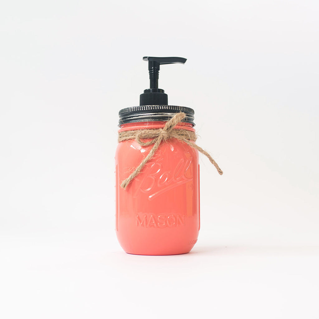 A coral-colored mason jar soap dispenser with a pump on a white background.