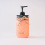 A coral-colored mason jar soap dispenser with a black pump on a white background.