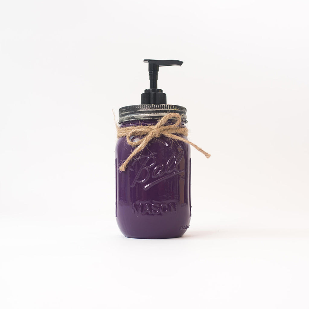 A purple mason jar soap dispenser with a pump and twine on a white background.