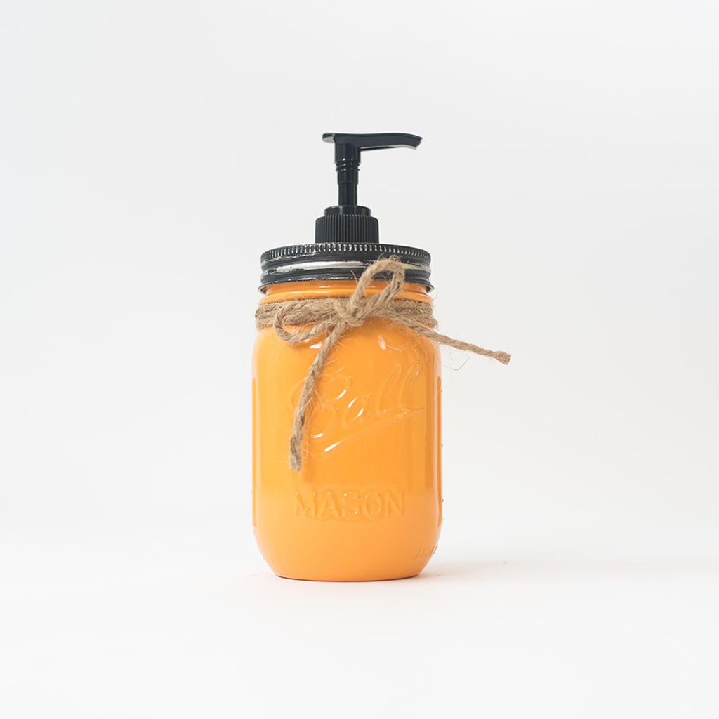 An orange mason jar soap dispenser with a pump on a white background.