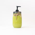 A green mason jar soap dispenser with a pump on a white background.