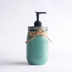 A teal mason jar soap dispenser with a pump on a white background.