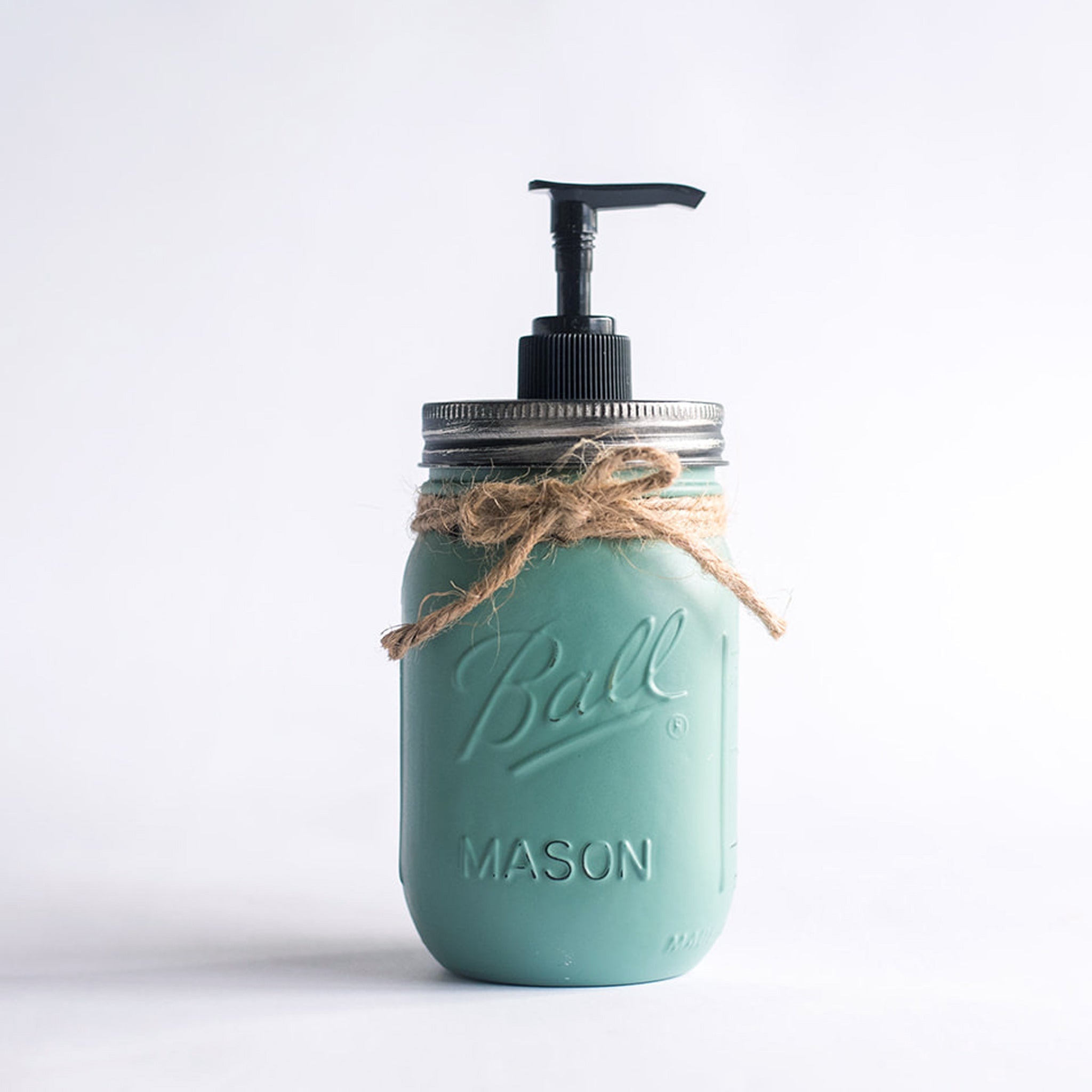 A teal mason jar soap dispenser with a pump on a white background.