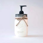 A white mason jar soap dispenser with black pump and twine bow on a white background
