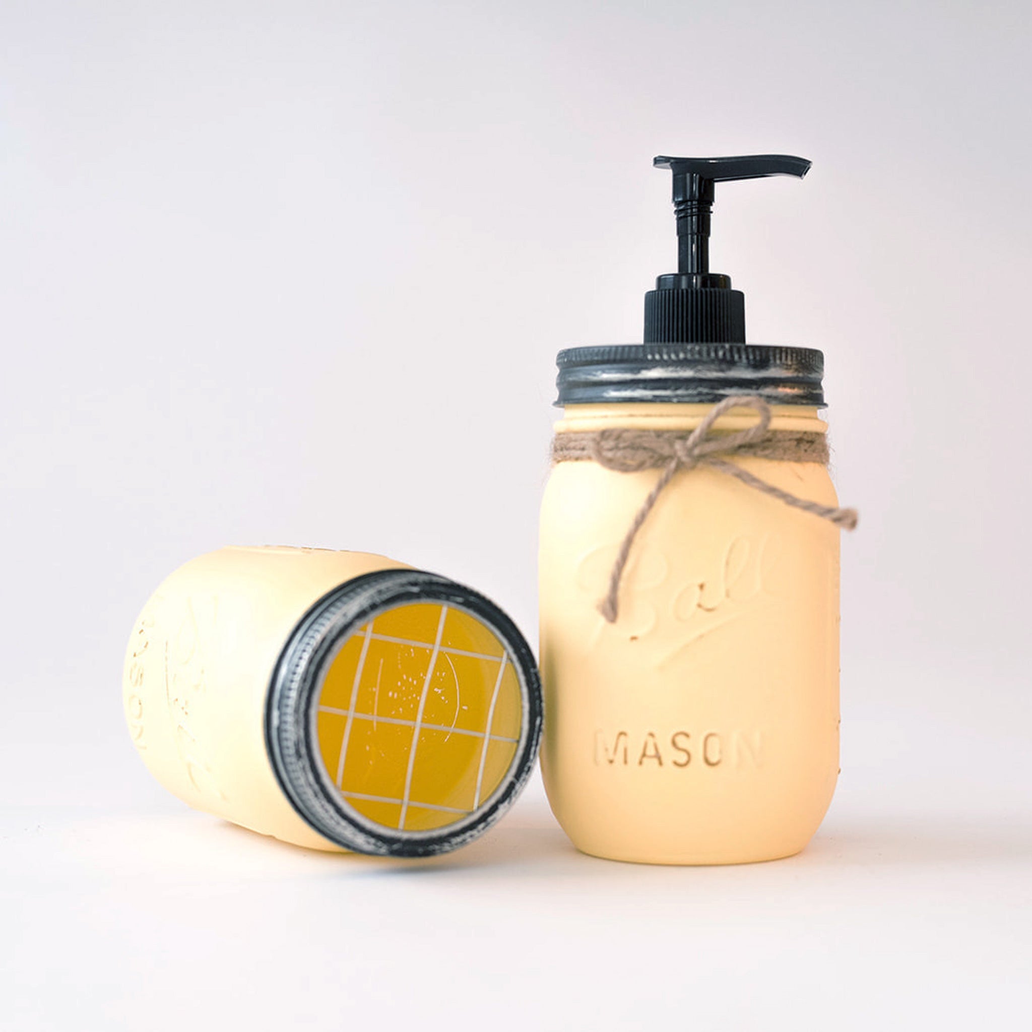 Mason jar soap dispenser and toothbrush holder on a white background.