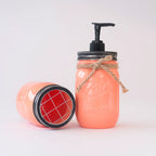 Coral-colored mason jar with pump and lid on a white background.