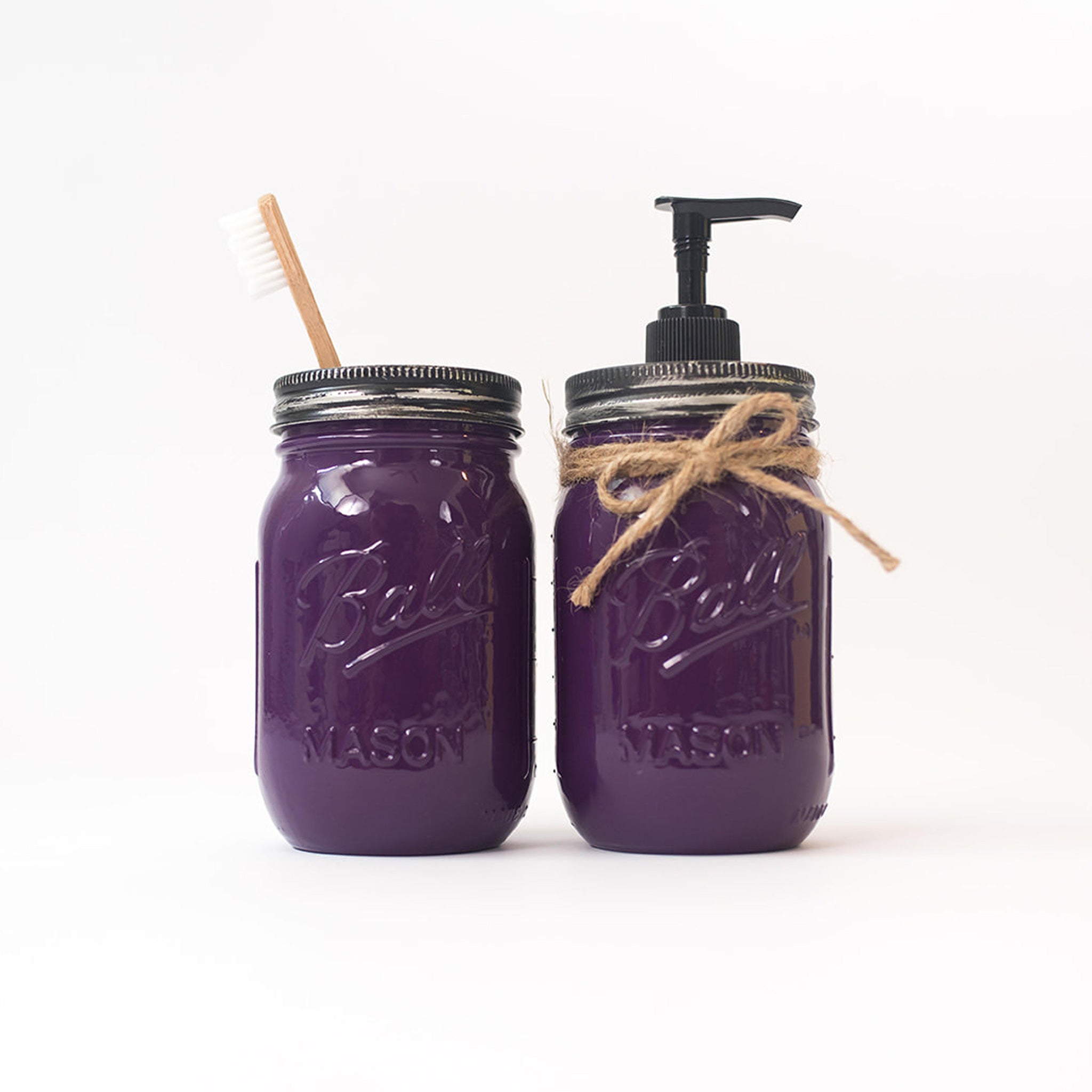 Two purple mason jars with a straw and pump dispenser on a white background.
