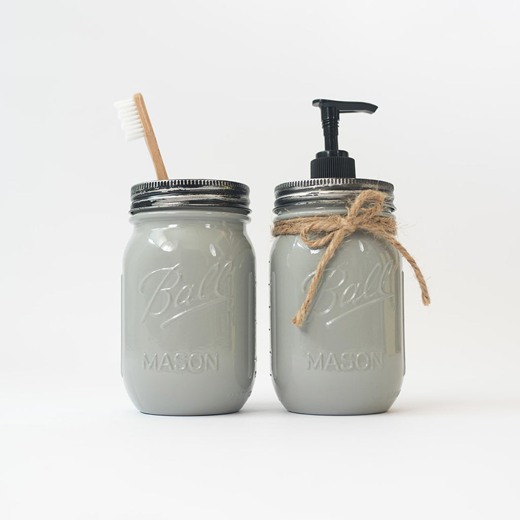 Two gray mason jars with a brush and pump dispenser on a white background.