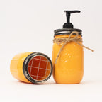 Yellow mason jar soap dispenser with pump and twine on a white background.