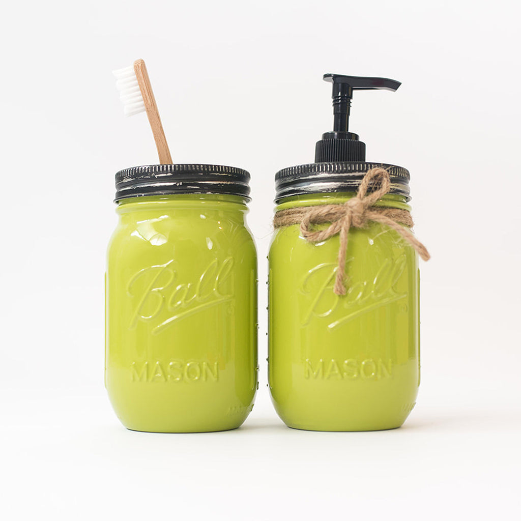 Two green mason jars with a straw and pump on a white background.