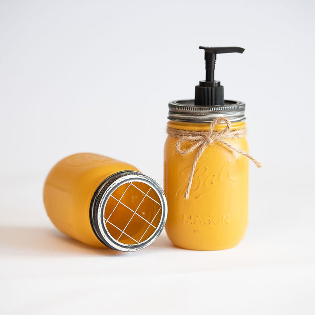 Yellow mason jar soap dispenser with pump on a white background.