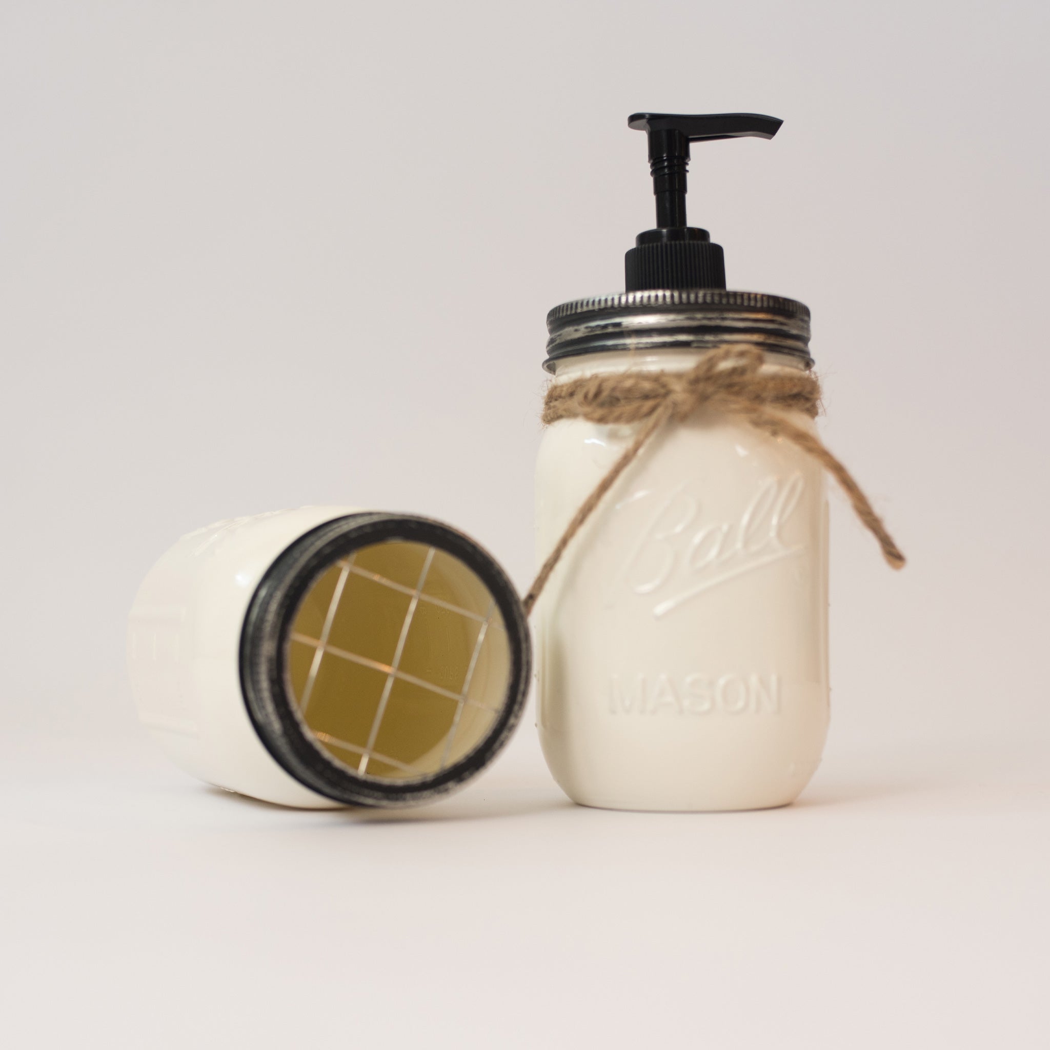 Mason jar soap dispenser with pump on a white background.