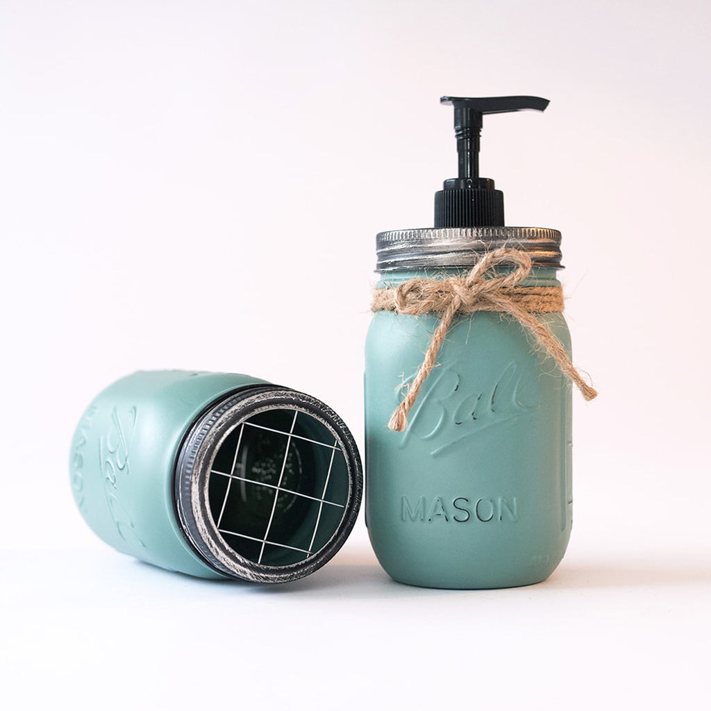 Mason jar soap dispenser with pump and twine on a white background.