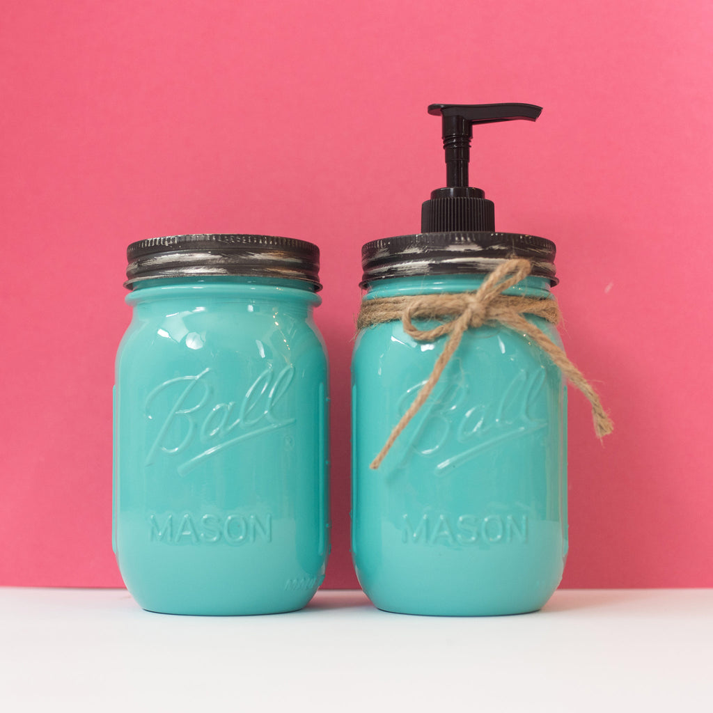 Two turquoise mason jars with a pump and lid against a pink background.