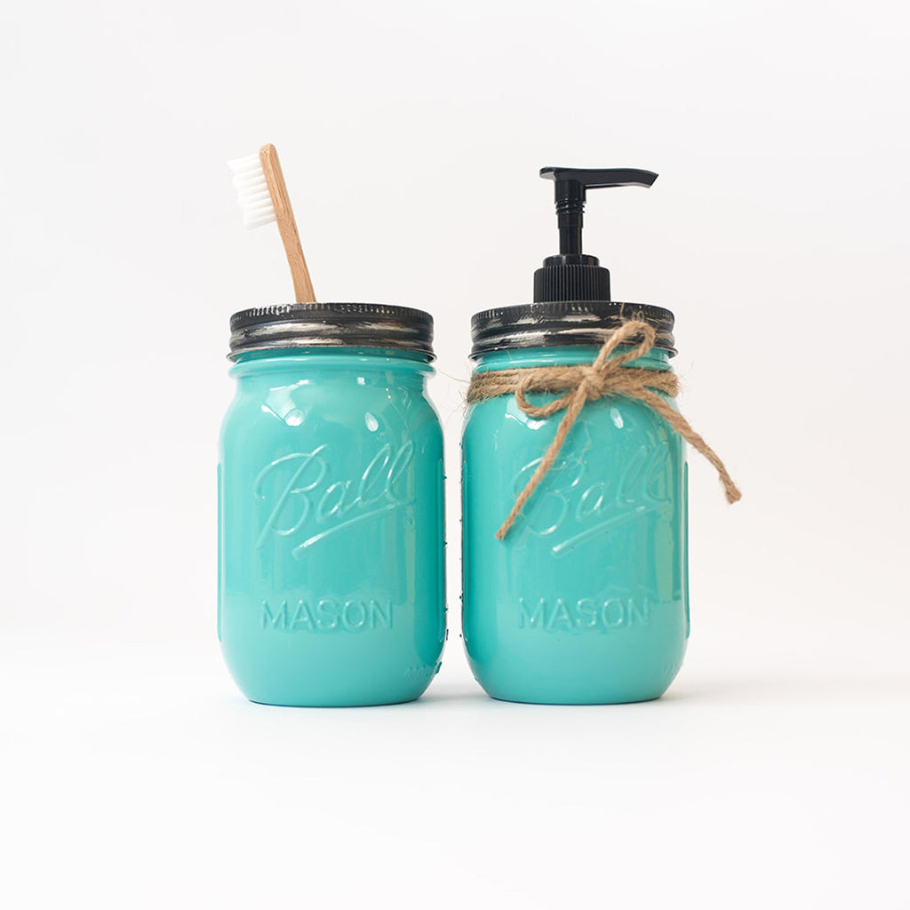Two turquoise mason jars with a straw and pump on a white background.
